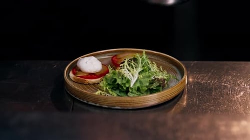 Close Up in a Professional Kitchen on Clean Metal Table a Woman Chef Collects a Salad with Fresh