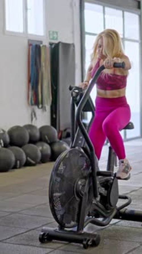 Woman Exercising on Stationary Bike at the Gym