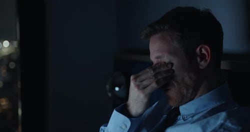 businessman working on laptop late night, Workaholic guy face illuminated by screen's glow.