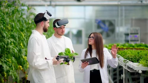 Scientists Using Technology in a Greenhouse Setting