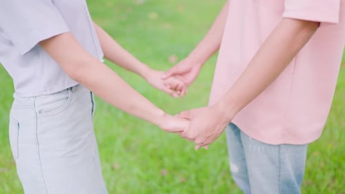 Hand-in-hand Love: A couple holding hands in the park, radiating happiness and togetherness amidst n