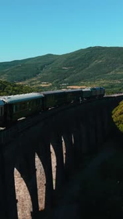 Vintage Passenger Train Crossing Picturesque Viaduct in European Mountain Landscape