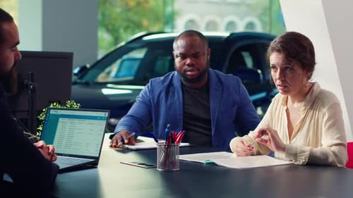 Car Dealership Salesman Looking Over Appointment List on Laptop Spreadsheet