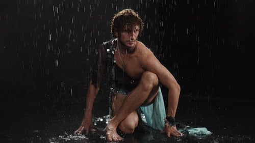Dynamic Male Pose in a Rainy Atmosphere Showcasing Energy and Expressive Aesthetic Vigor