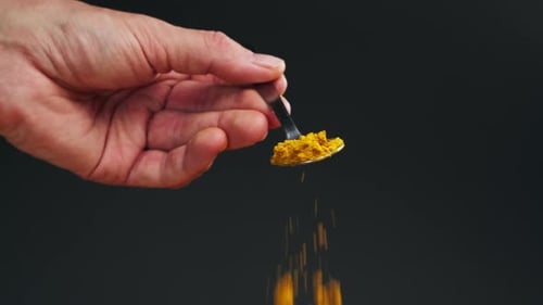 Spice Turmeric Powder on Spoon Close Up Sprinkle Turmeric Powder Spice for Food and Drinks Healthy