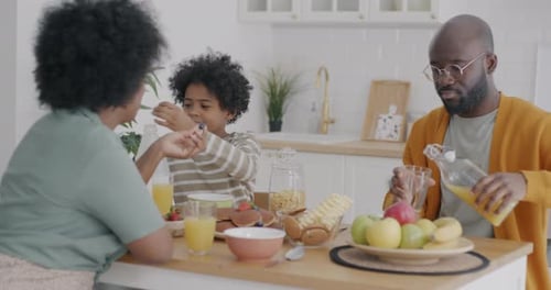 Family Enjoys Breakfast at Kitchen Table