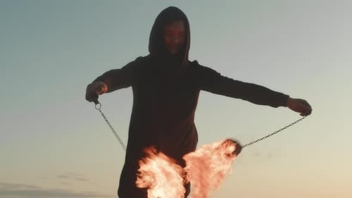 Young Adult Fire Dancing at Sunset