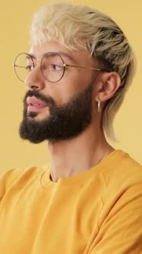 Close up, laughing man looking at camera isolated on yellow background in studio