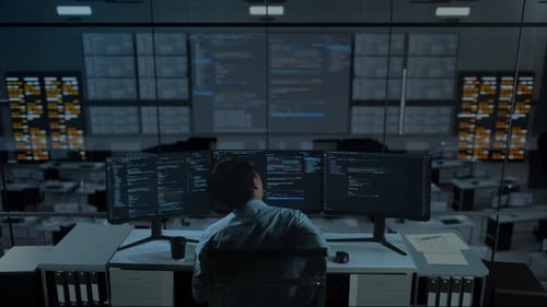 Asiatischer Mann hat Rückenschmerzen beim Schreiben von Code mit mehreren Computerbildschirmen im Büro