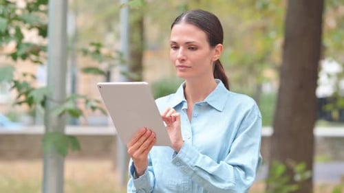 Woman using Tablet Computer in Park