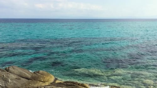 Sea and rocks. Clear water. Summer day. Cost and blue sky with clouds.