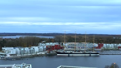 a panoramic view over the waterfront and marina area. A large sailing ship Passat is moored at the