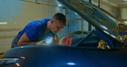 Mecânico de automóveis trabalha com um carro na garagem