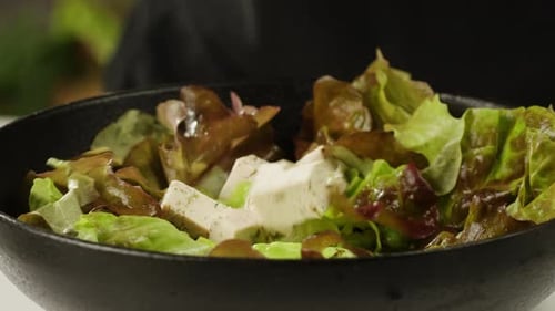Tofu frit aux graines de sésame et aux épices sur une poêle en fonte, cuisson d'une salade japonaise, ingrédient sain