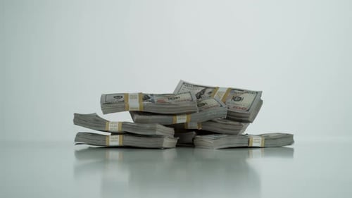Falling Stacks of United States Currency on White Surface