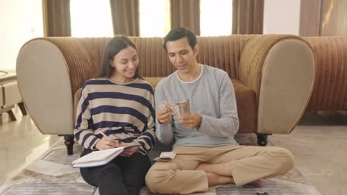 Happy and rich Indian couple counting money and doing future planning
