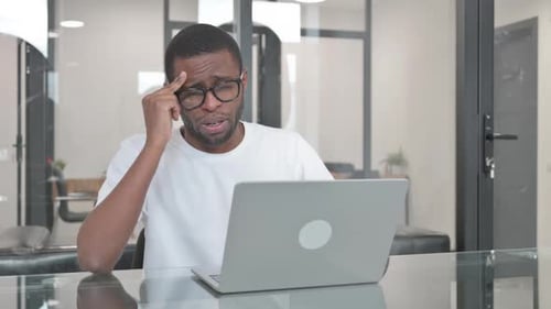 Young Adult Working At Laptop In Bright Office