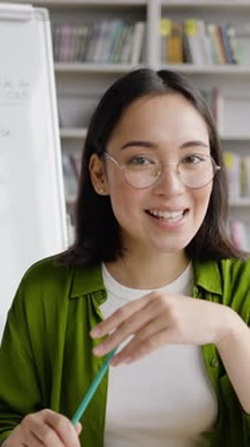 Smiling Young Woman Explaining Lesson By Whiteboard