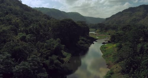 Drone view of foggy tropical river at sunrise with lush forest