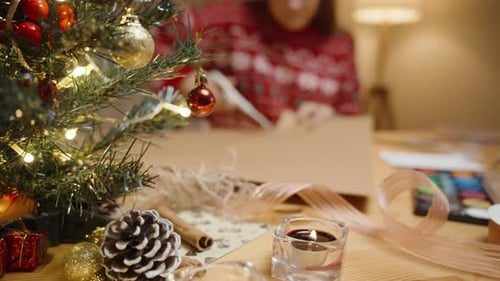 Woman Crafting Festive Christmas Holiday Decoration at Table