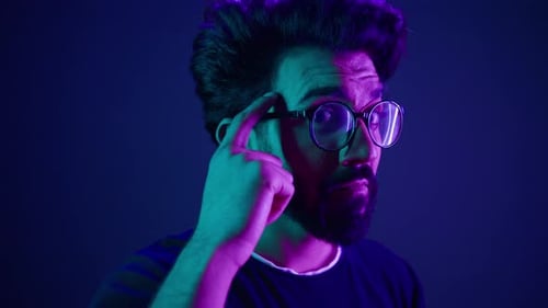 Indischer Entwickler, Programmierer, Computer, intelligenter, cleverer Hacker mit Brille, Neon-Ultraviolett-Studio