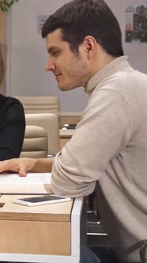 Man and Woman Reading a Book at Table