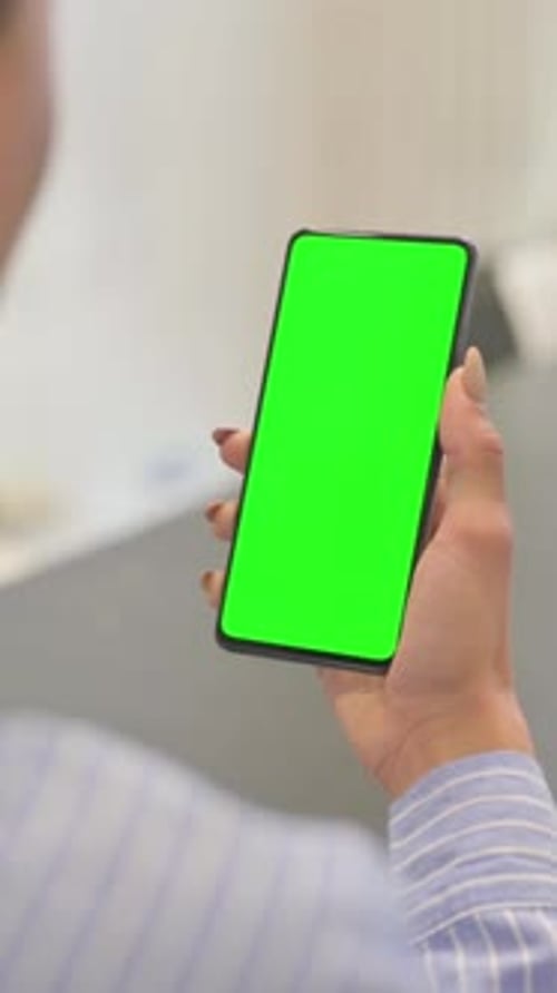 Holding Phone with Chroma Key on the Screen, vertical video