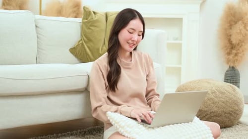 Young Woman Happily Using Laptop in Bright Home