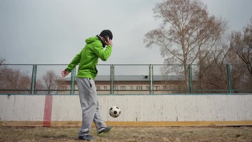 Man in Focused Stance Delivers Potent Kick Under Cloudy Skies Athletic Male on City Field Strikes