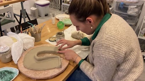 Woman Shaping Clay Sculpture in Art Studio