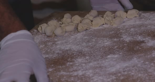 Close up shot of many traditional dumplings being placed on a floured ...