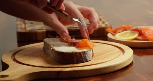 Side View Chef Places Slices of Salted Salmon on Buttered Bread to Make an Open Sandwich in Warm
