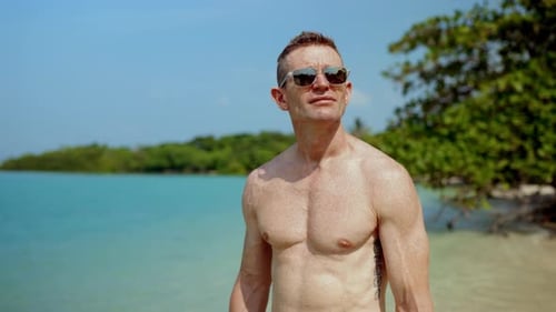 Adult Man Stands on Tropical Beach Gazing