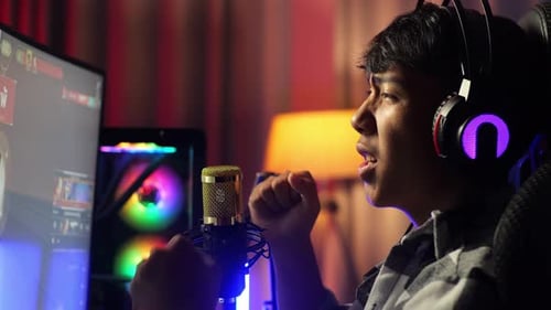 Close Up Of Asian Boy Streamer Celebrating Winning Game On Personal Computer