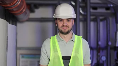 Confident Engineer in Boiler Room Inspects Heating System Equipment