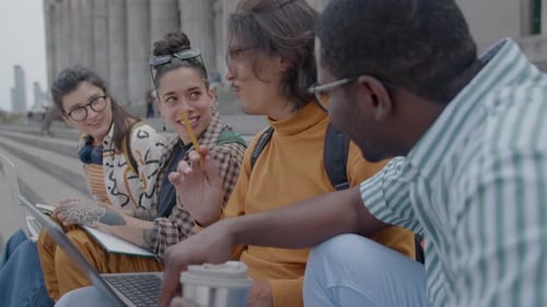 Young Groupmates Doing Homework Together on Stairs outside University