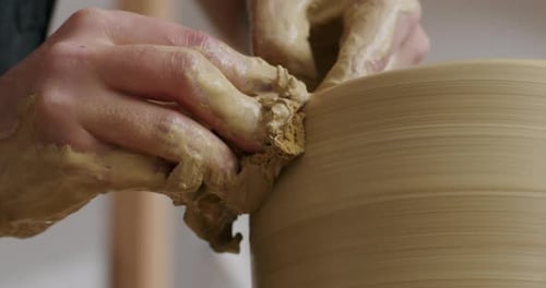 Finition d'un vase en potier sur un tour de potier avec les mains