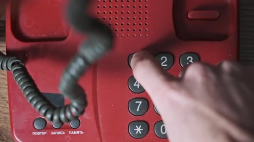 Calling 911 On an Old Retro Red Telephone with Dial Buttons Top View