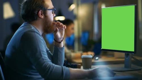 Creative Bearded Man Works on a Personal Computer with Isolated Mock-up Green Screen. His Office Sp