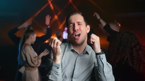 Hübscher modischer Mann tanzt im beleuchteten Nachtclub, Taschenlampe, Party, Unterhaltung, Wochenende, Freizeit