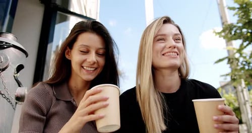 Young Women Enjoying Coffee on Street