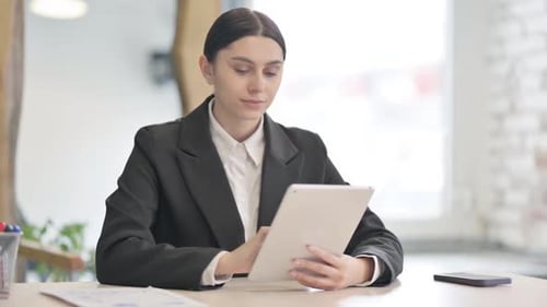 Professional Woman Using Tablet Device in Modern Office