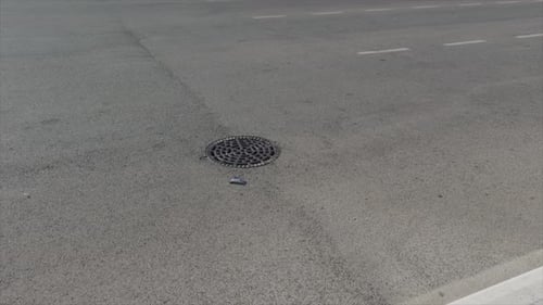 Tampa de bueiro na superfície da estrada de asfalto em Marrocos
