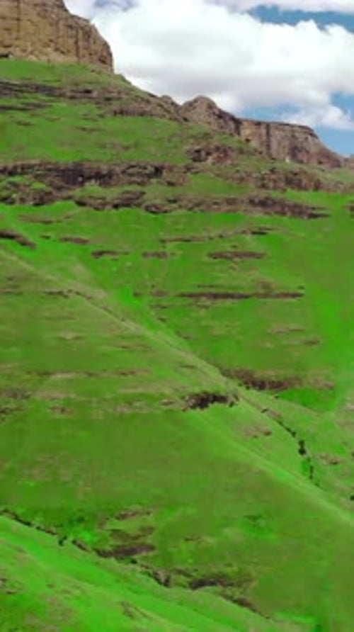 Idyllic Aerial View of Lush Pastures and Layered Escarpments Under Bright Tranquil Weather