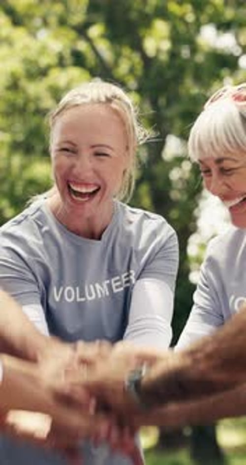 Smiling Volunteers Putting Hands Together in the Park