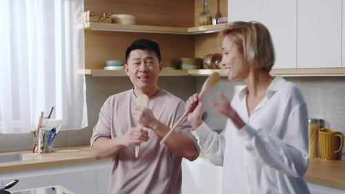 Couple Singing and Dancing in Modern Kitchen