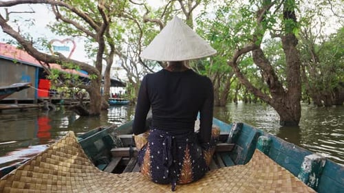 Woman Boating Through Tropical River Surrounded by Trees