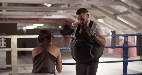 Woman Boxing with Trainer in Gym