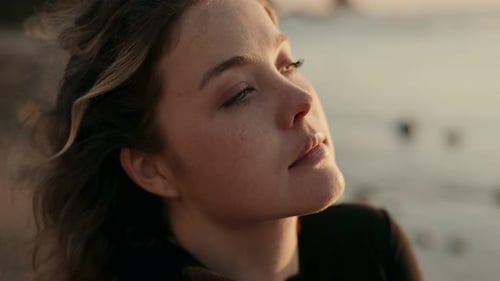 Young Woman Reflecting on Beach at Sunset