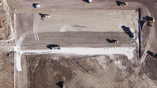 Konstruktion mit einem Bulldozer. Ansicht von oben. Ein gelber Bulldozer fällt mit einem Eimer zu Boden